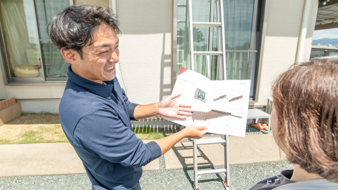お客様に資料を見せて説明している様子